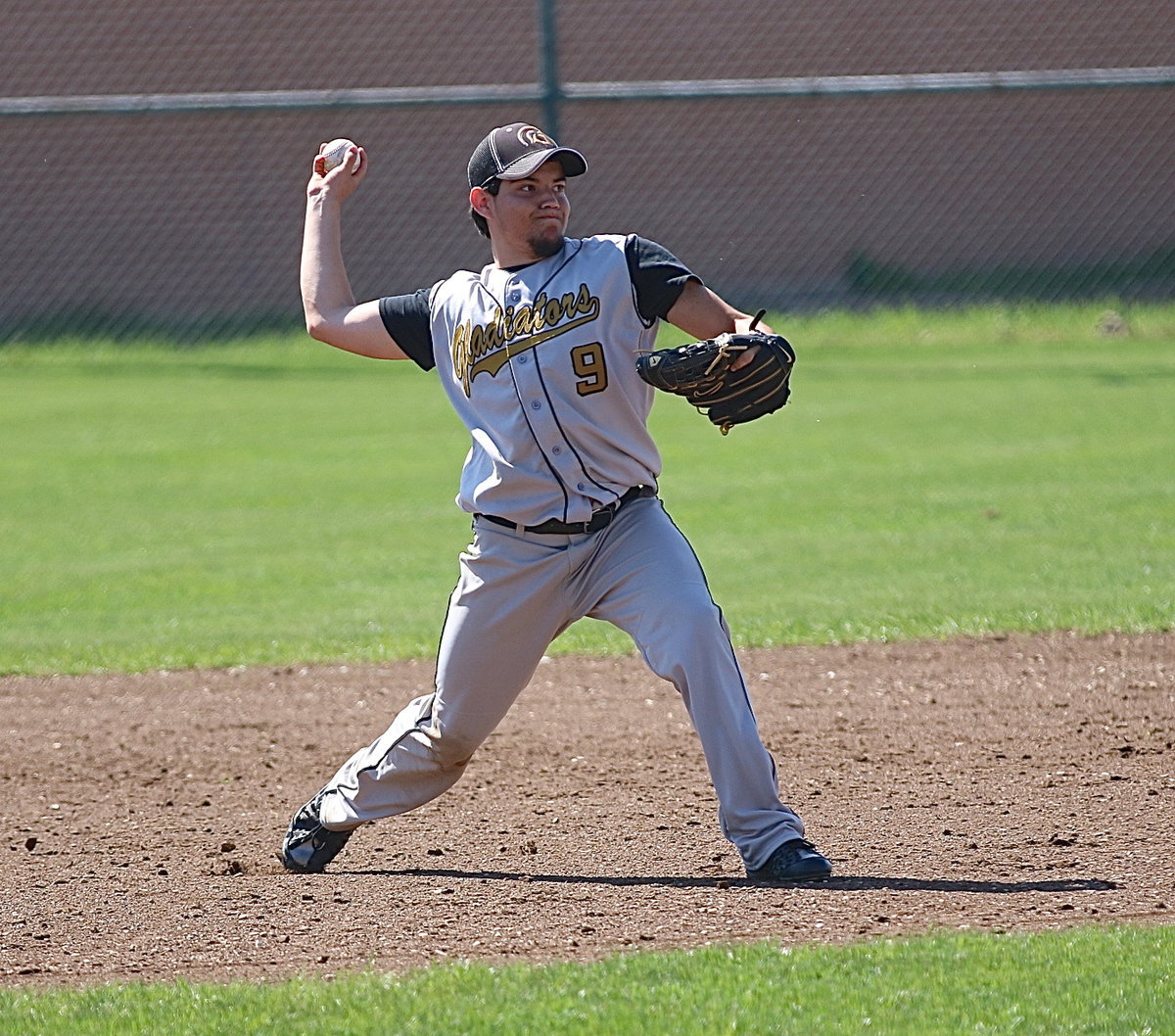 Image: Italy’s Tyler Anderson(9) throws to first-base for an out.