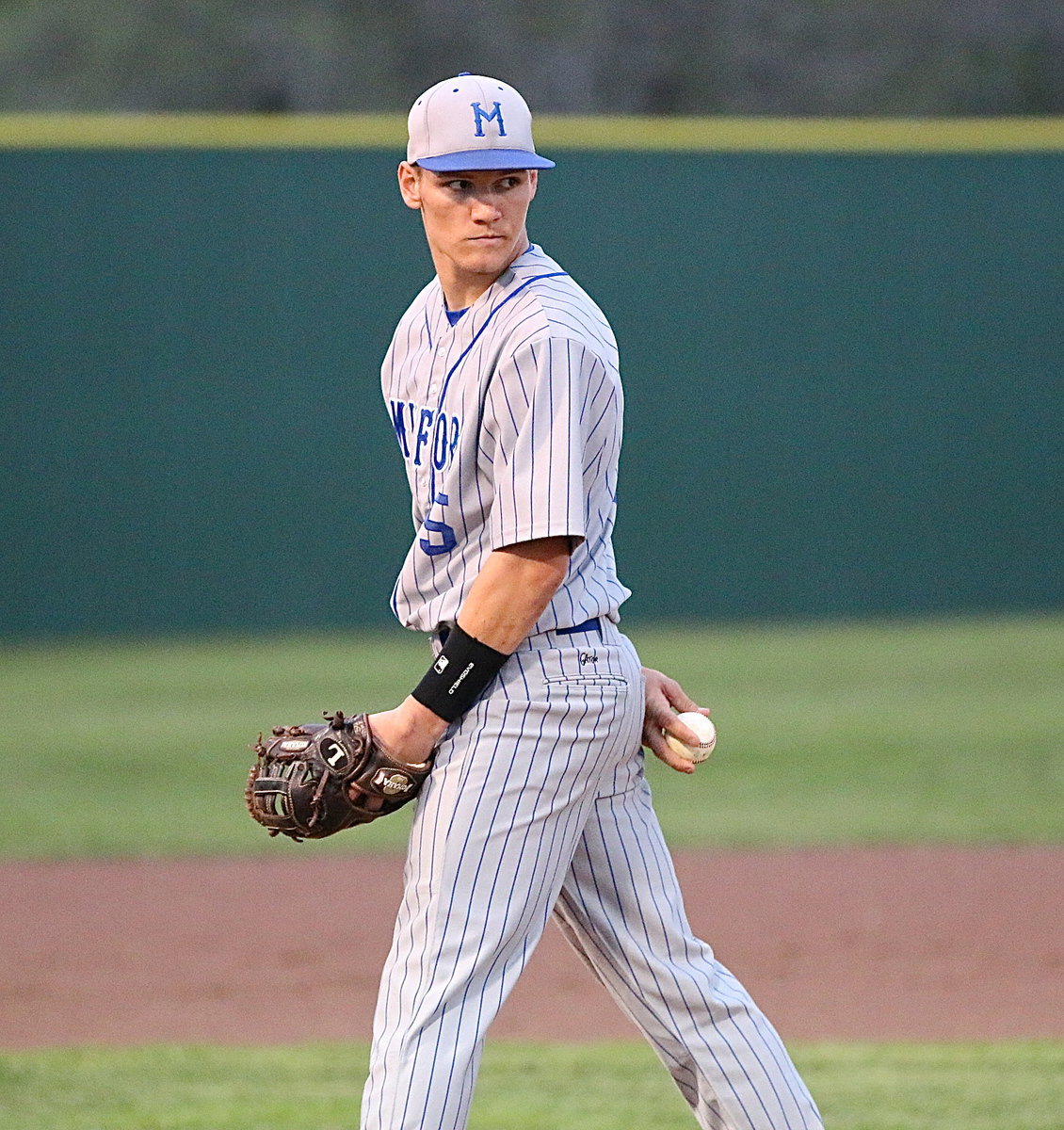 Image: Senior Bulldog pitcher Eric Evans(5) checks a Gladiator runner on first-base. Evans recorded 9 strikeouts against the Gladiators.