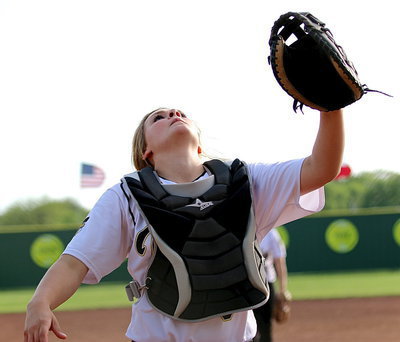Image: Lady Gladiator catcher Lillie Perry(9) sheds her face mask and then catches a pop-up near the backstop fence.