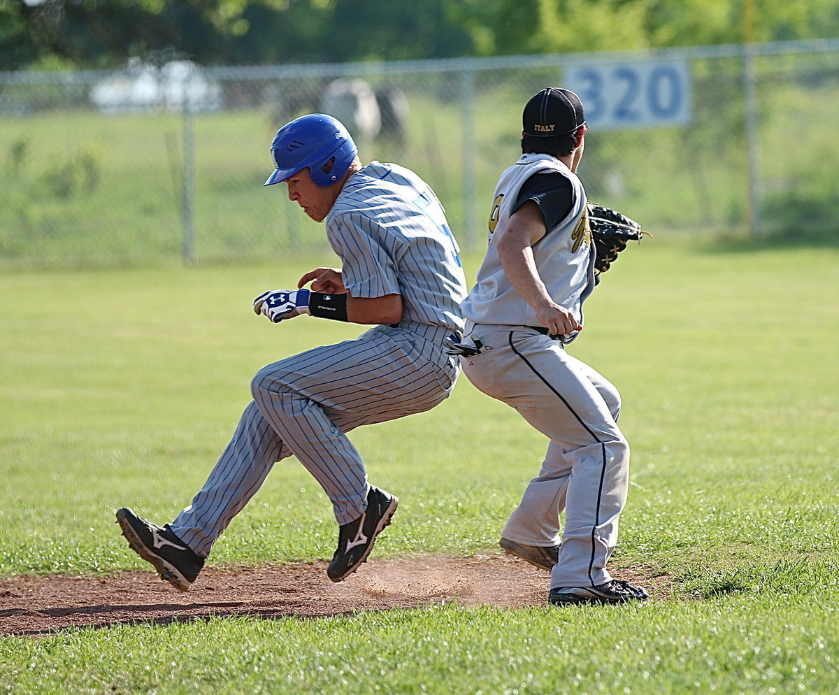 Image: MIlford’s Eric Evans(3) slips past a tag attempt from Italy’s shortstop, Tyler Anderson(9).