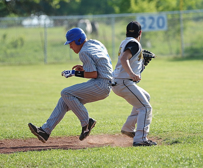 Image: MIlford’s Eric Evans(3) slips past a tag attempt from Italy’s shortstop, Tyler Anderson(9).