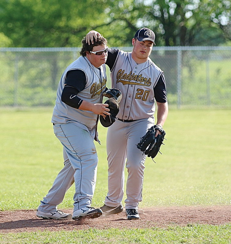 Image: Zain Byers(20) gives his cousin, John Byers(16) some love after John made the diving tag against Milford to collect all three outs needed for Italy’s defense.
