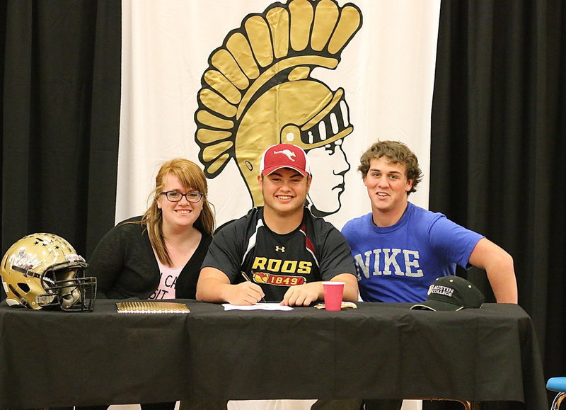 Image: Emily Stiles and JoeMack Pitts pose with their senior classmate, Zain Byers, after Byers made it official to play football for the Austin College Kangaroos!