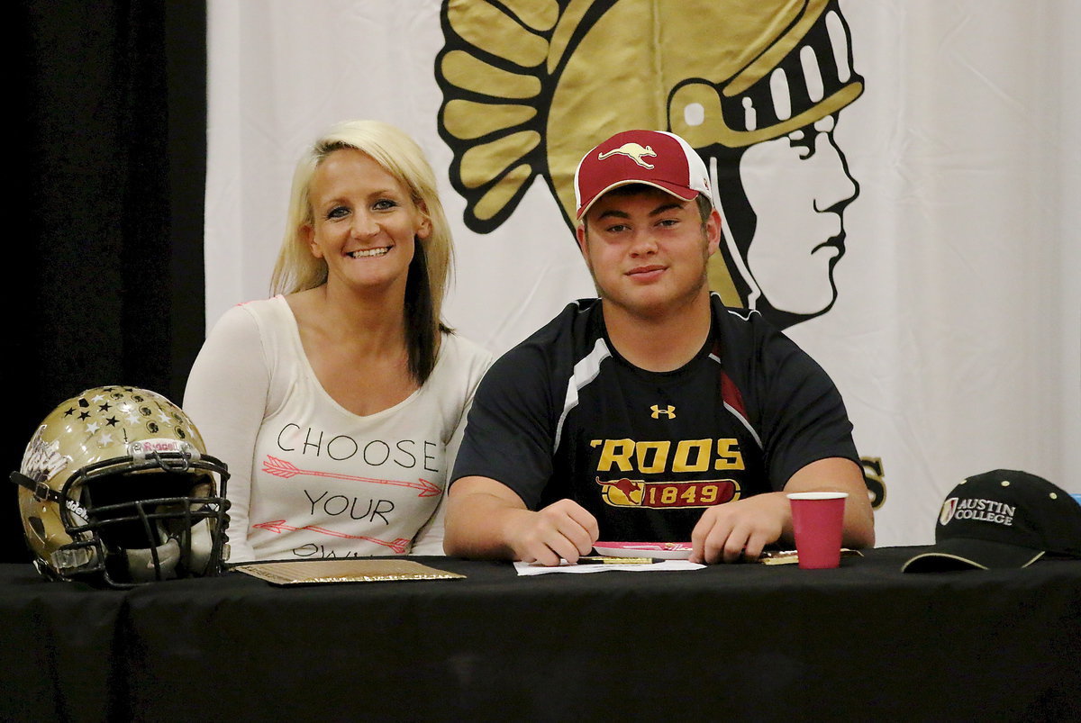 Image: Coach Morgan Mathews is excited about Zain Byers signing his college commitment letter to play football while the ‘Roo of the hour tries to downplay the fact he’s eating cake in this picture.