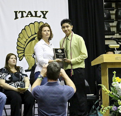 Image: The Shelley Nance Memorial Scholarship is presented by Shelley’s mother, Cynthia Nance, to talented senior artist, Joseph Sage. That’s Shelley’s father, Sam Nance, down in front capturing the moment.