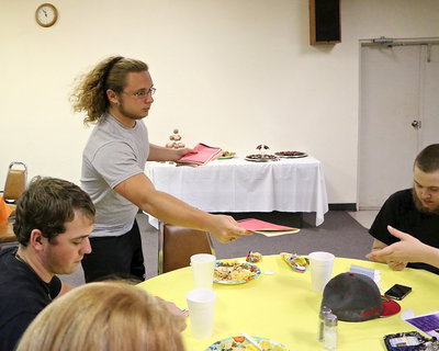 Image: Shad Newman passes out survival pamphlets to Joseph Pitts, Tristan Smithwick and the rest of the graduates.