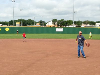 Image: Softball Coach Michael Chambers pitches to the ladies during the scrimmage.