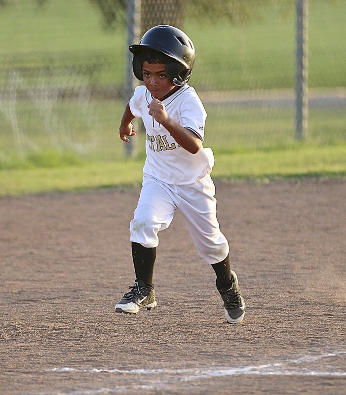 Image: Cason Green(10) has a determined look as he charges for home plate to score a run for the IYAA T-Ball Gladiators during their first-round game of the district tournament held in Hillsboro.