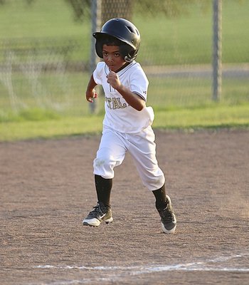 Image: Cason Green(10) has a determined look as he charges for home plate to score a run for the IYAA T-Ball Gladiators during their first-round game of the district tournament held in Hillsboro.