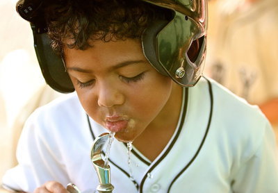 Image: Cason Green(10) takes a quick sip of water before taking his turn at bat for Italy.