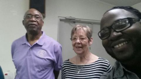 Image: Charles and Linda, volunteers, strike a pose with Pastor Lamar Jones at the luncheon.