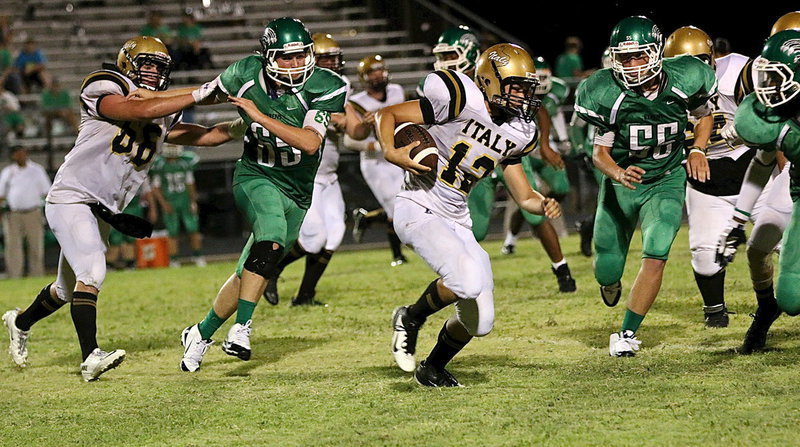 Image: Gladiator senior center Kyle Fortenberry(66) tries to spring freshman runner Kyle Tindol(12) who is being tracked by a pack of Bobcats.