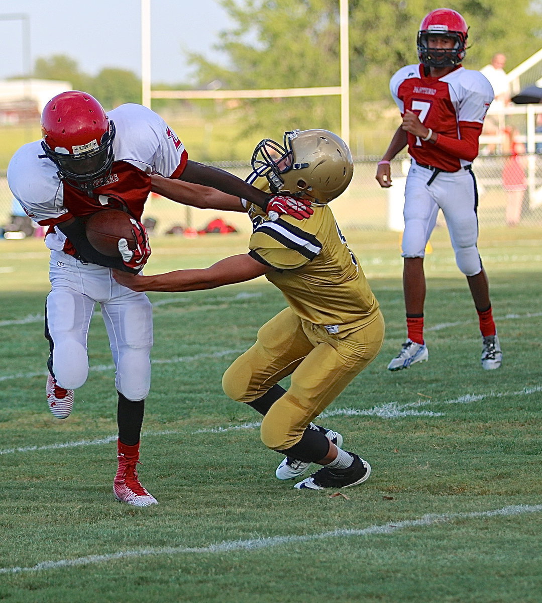 Image: Italy’s Gary Escmailla(7) fights thru a stiff paw to help bring down a Panther back.