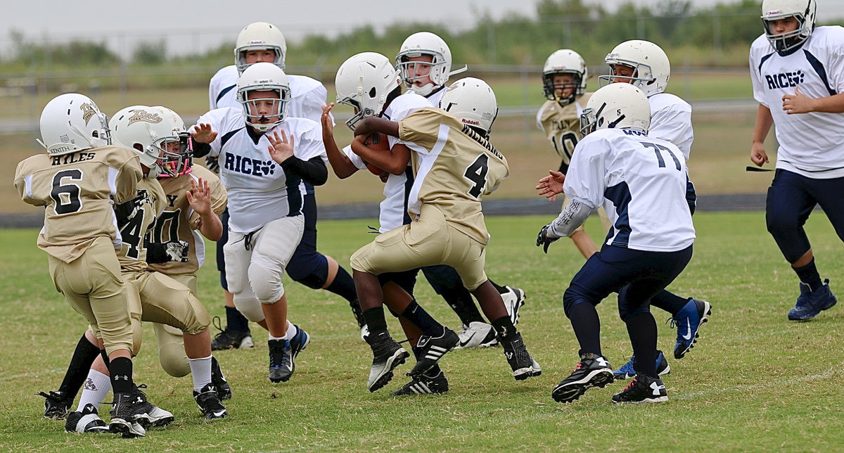Image: A-team Gladiator Julius Williams(4) wraps up a Bulldog runner in traffic.
