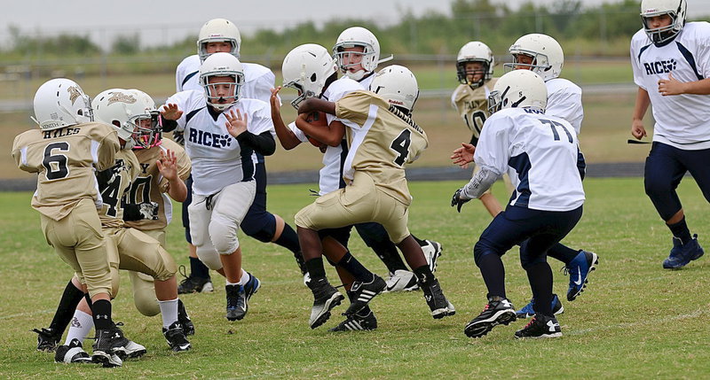 Image: A-team Gladiator Julius Williams(4) wraps up a Bulldog runner in traffic.