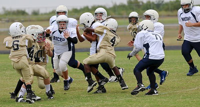 Image: A-team Gladiator Julius Williams(4) wraps up a Bulldog runner in traffic.