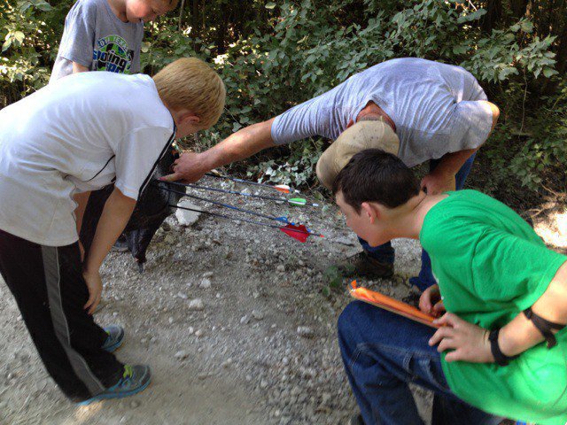 Image: Hunter Hinz and his squad of shooters from other counties decipher the scoring on one of the targets. The youth are in charge of scoring each others targets.
