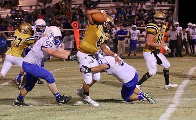 Image: Gladiator quarterback Joe Celis(8) maneuvers thru traffic during a long run.