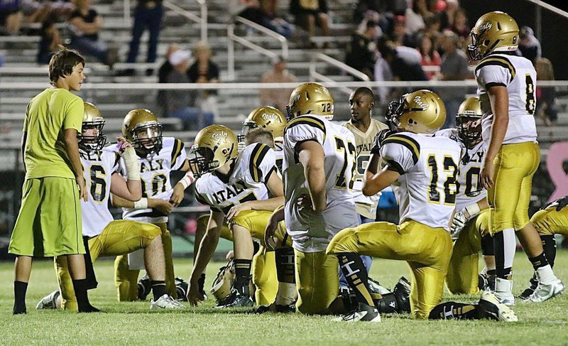 Image: Team managers Brentlee Grant and John Hall, Jr., water the Gladiator defense during an injury timeout.