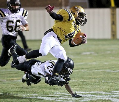 Image: Kendrick Norwood(4) is finally tripped up by a Bulldog nipping at his heels after a nice gain for the Gladiators.