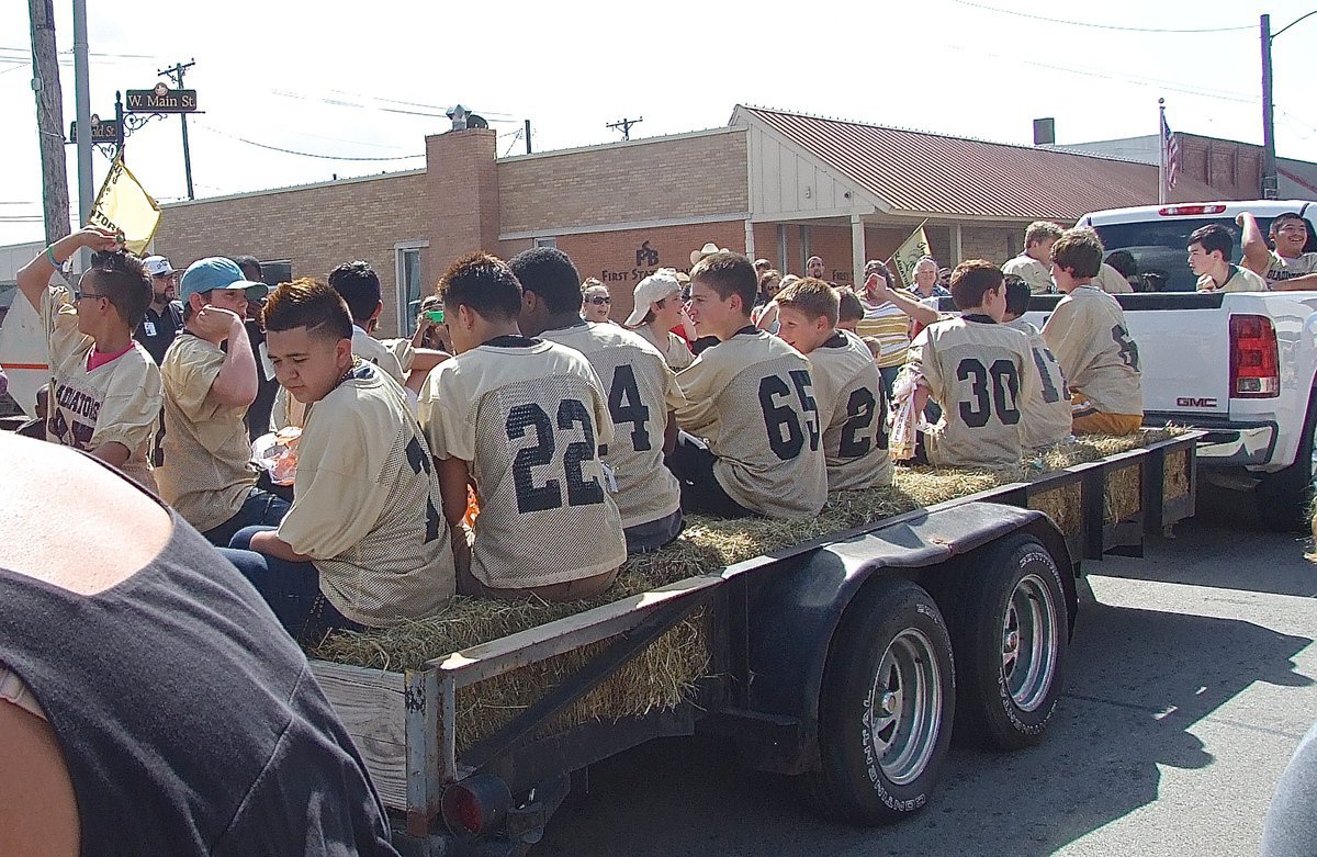 Image: The junior high Gladiators pass by and pitch candy to the fans.
