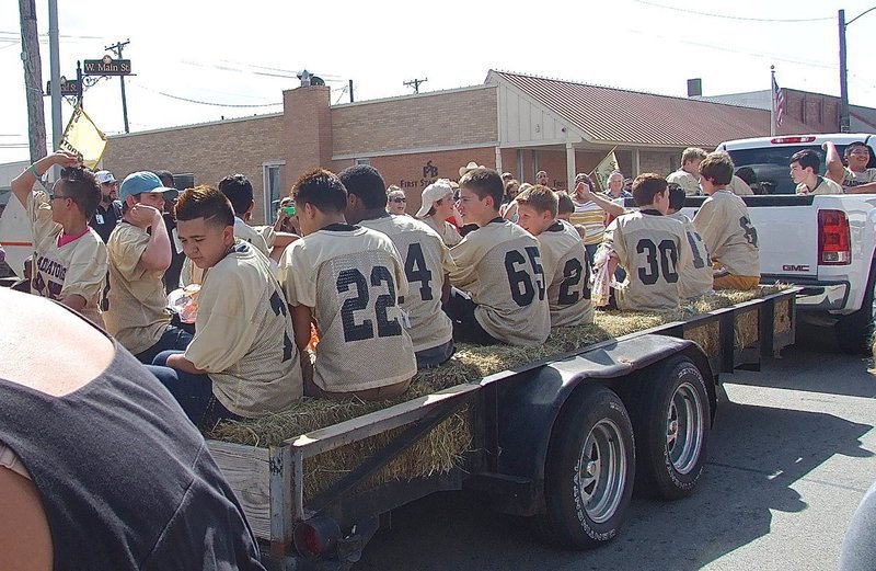 Image: The junior high Gladiators pass by and pitch candy to the fans.