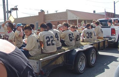 Image: The junior high Gladiators pass by and pitch candy to the fans.