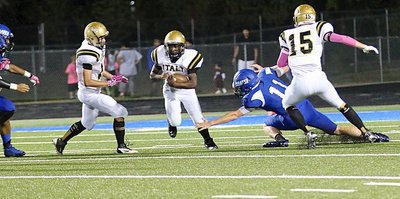 Image: Gladiators Kyle Tindol(12) and Cody Boyd(15) try to spring running back Kendrick Norwood(4) into the clear.