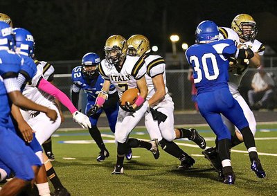 Image: Gladiator Ryan Connor(7) runs behind a block from teammate Austin Pittmon(65).