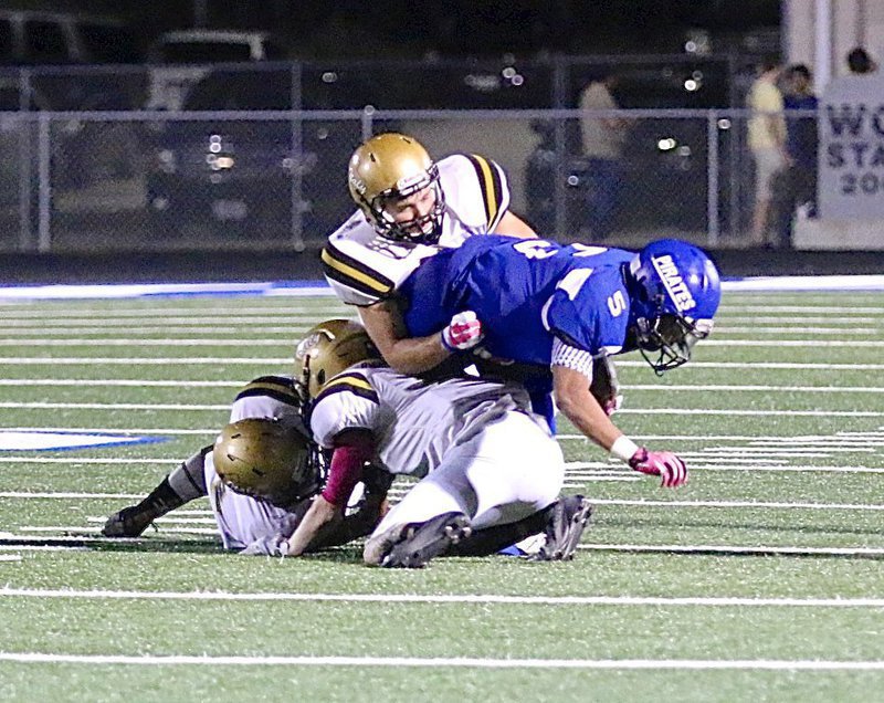 Image: Gladiator Hunter Merimon(3) hangs on to bring a Chilton ball handler down to the turf with help from teammates.