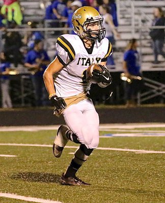 Image: Italy’s Levi McBride(1) looks for a running lane during a kick return.