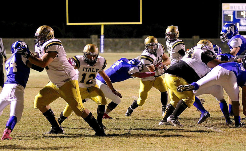 Image: Italy’s Hunter Merimon(3) tries to hit the hole created by teammates Aaron Pittmon(72), Kyle Tindol(12), and Ty Fernandez(64) against Wortham.