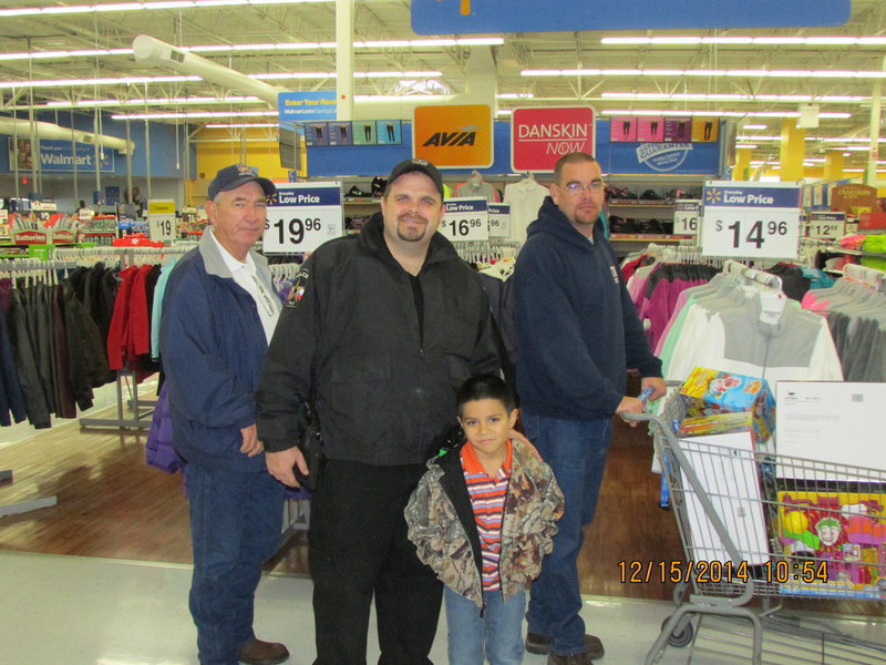 Image: Chief Chambers, Officer Cherry, Lt B. Chambers and JR with a buggy full of gifts.