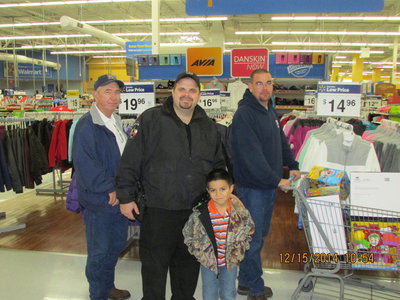 Image: Chief Chambers, Officer Cherry, Lt B. Chambers and JR with a buggy full of gifts.