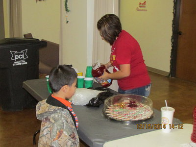 Image: Manuela Martin pouring punch while JR watches over the cookies.