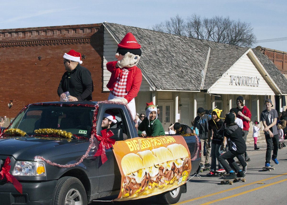Image: Pizza Inn’s original pizza-tossing, moustache-wearing mascot, JoJo, invite parade goers “inn” for some fresh-baked pizza on the buffet. Pizza Inn of Italy also offers delivery and carryout. Skateboarders hungry for pizza are not far behind.