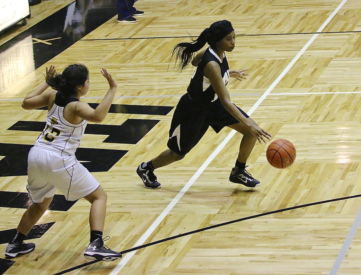 Image: JV Lady Gladiator Janae Robertson(10) makes a move toward the lane while eluding a Lady Cat defender.