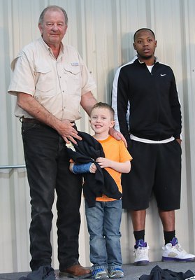 Image: City of Italy’s Mayor James Hobbs presents IYAA C-team offensive guard Grant Morgan(6) with his Superbowl Championship hoodie. C-team special teams coach Andre Speed is also pictured.
