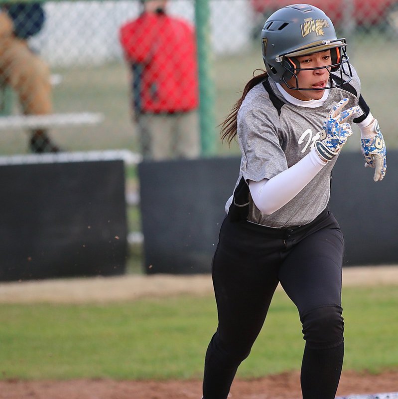 Image: Lady Gladiator speedster April Lusk(7) dashes to first-base in the blink on an eye.