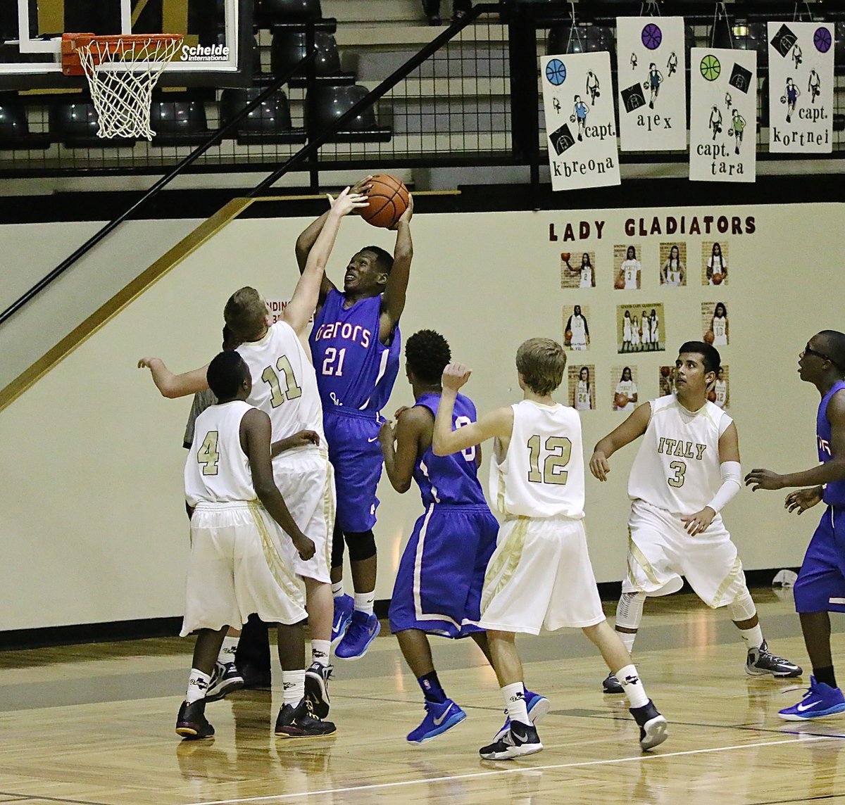 Image: JV Gladiator James Walton(11) disrupts a shot attempt by the Gators.