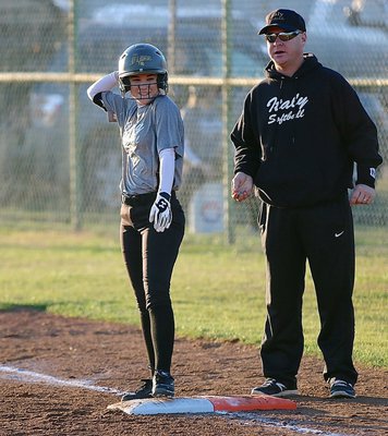 Image: Cassidy Childers(3) straightens her war bonnet after hitting her way on base.