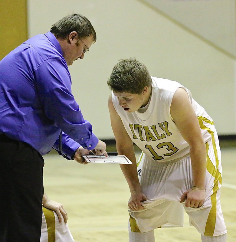 Image: Gladiator head coach Brandon Ganske draws up a play for senior John Escamilla(13).