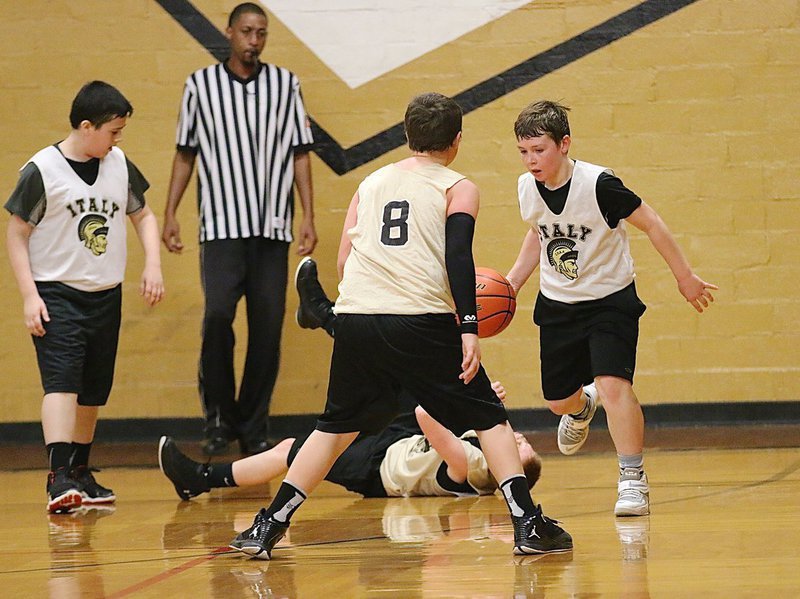 Image: Italy White’s Bryce DeBorde(5) works his way out of a jam as Italy Gold’s Jayden Saxon(8) and Ty Cash(10) try to slow him down.