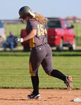 Image: Lady Gladiator Jaclynn Lewis(15) rounds second base during her homerun lap for the second time, adding insult to injury as the owner of the red truck she dented sits and watches.