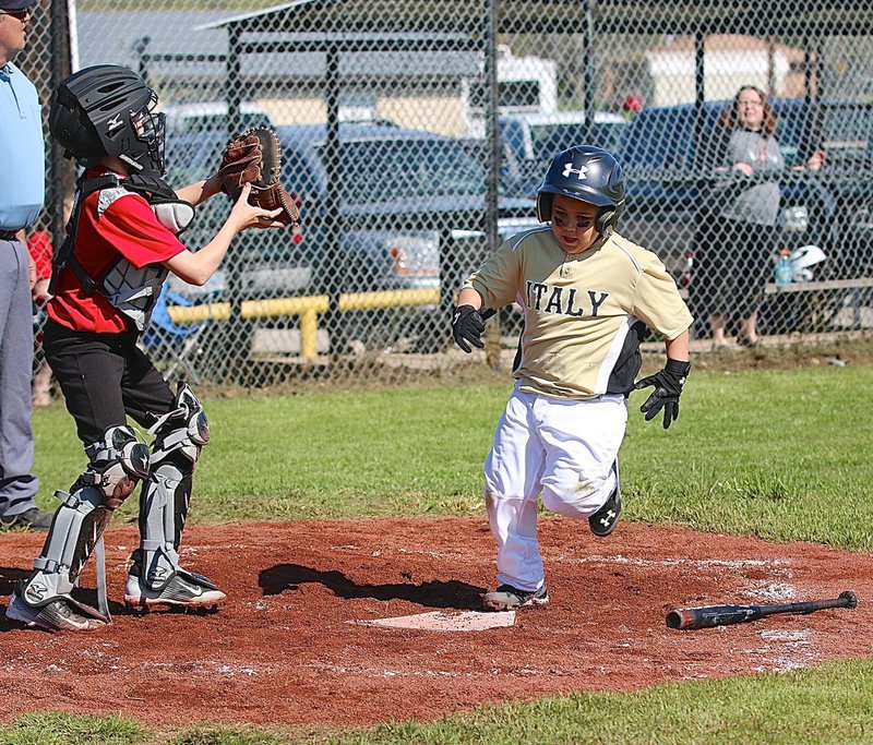 Image: Hagan Carr beats the throw home to score a run for Italy.