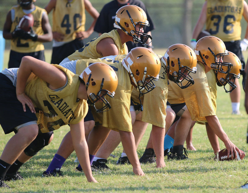 Image: The offensive line of the mighty Gladiators goes thru its paces with quarterback Joe Celis under center.