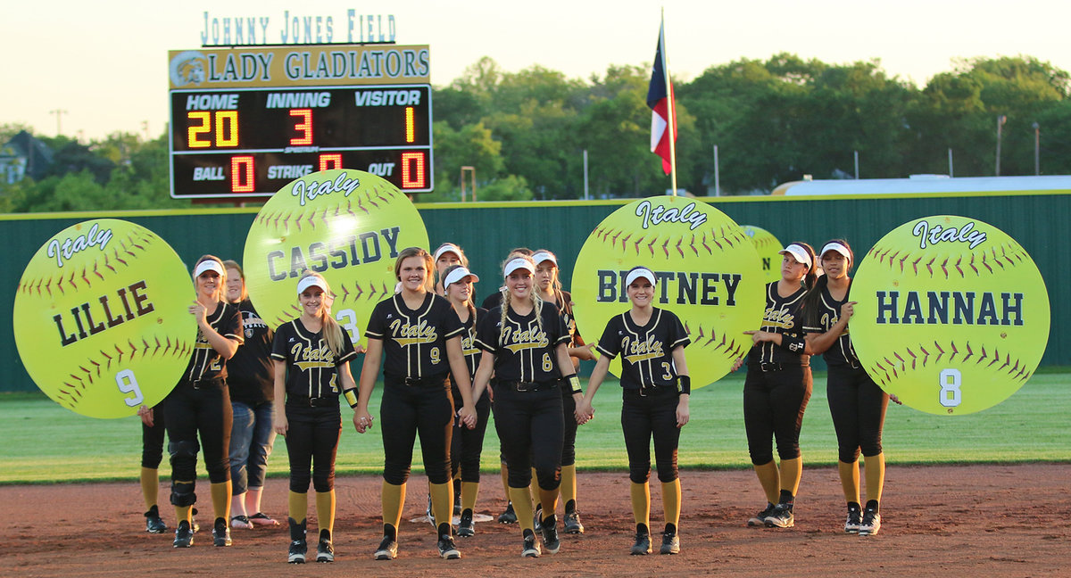 Image: Senior Italy Lady Gladiators Britney Chambers(4), Lillie Perry(9), Hannah Washington(8) and Cassidy Childers(3) are joined by their teammates during their Senior Walk at Johnny Jones Field.