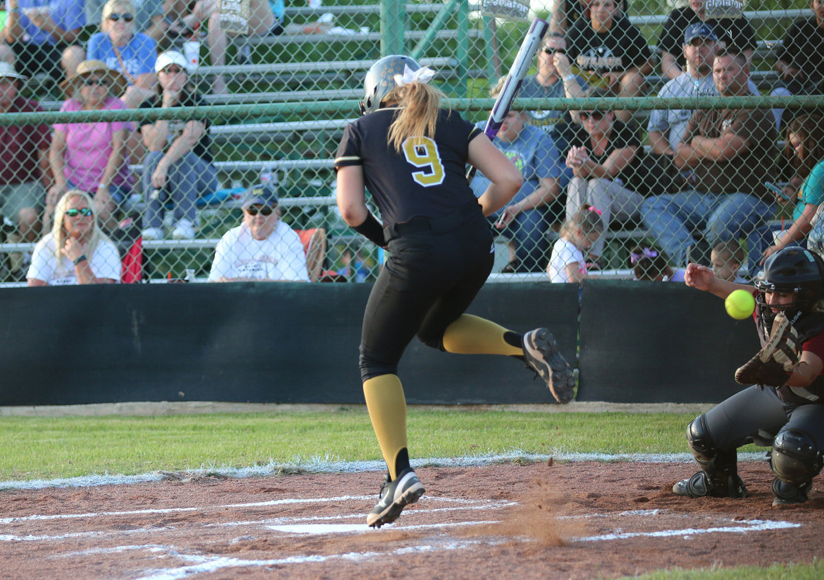 Image: Italy’s Lillie Perry(9) is unable to avoid being clipped by a pitch and is allowed to take her base.