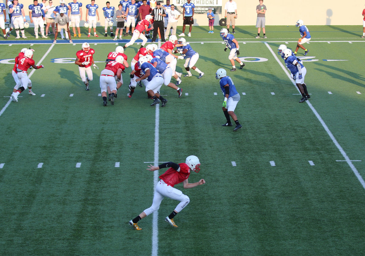 Image: receiver Clayton Miller(8), at the bottom of the screen, is working hard even on a running play.