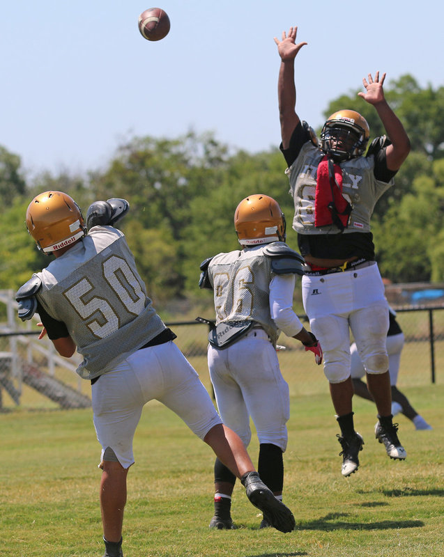 Image: QB Joe Celis #50 is forced to complete this pass around defensive tackle Kenneth Norwood #62 who leaped high to apply the pressure.